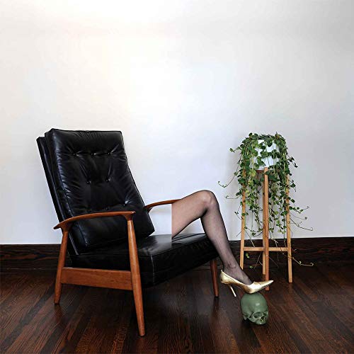Black chair, legs with stockings, and a skull under a foot.