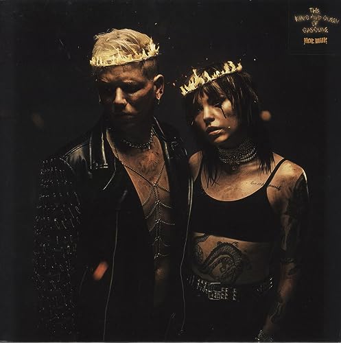 Two people with crowns and tattoos, dark and moody portrait.