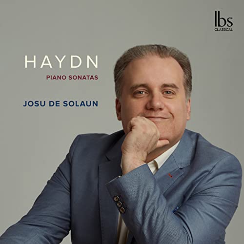Josu de Solaun in a blue suit, with text for Haydn Piano Sonatas.