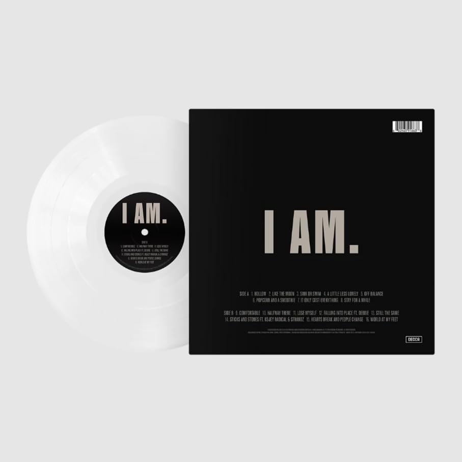 White vinyl record with black cover displaying “I AM.” text and tracklist.