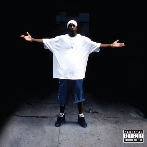 Big L standing with arms outstretched, wearing a white shirt and shorts.