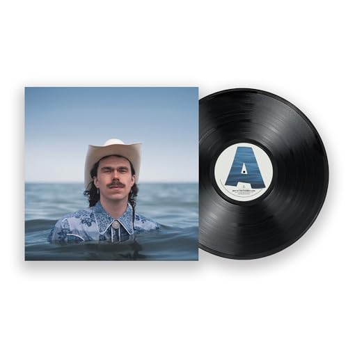 A man in a cowboy hat stands in water next to a vinyl record.