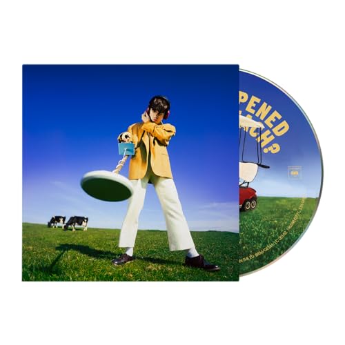Album cover: man with headphones, green field, cows, and a flying saucer.