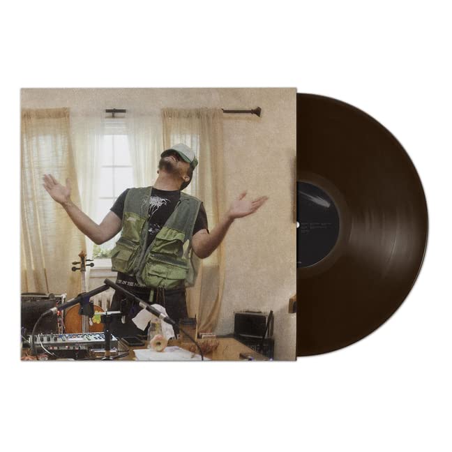 Album cover showing a man in a vest with arms raised, beside a brown vinyl.