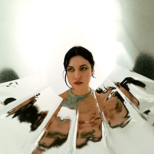 Woman with dark hair framed by reflective silver panels.