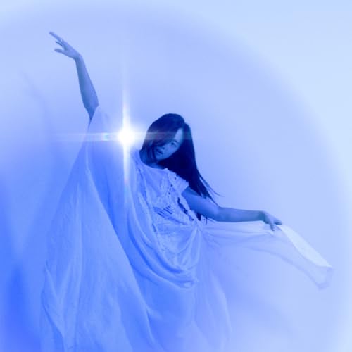 Woman in white dress with outstretched arm, bathed in blue light.