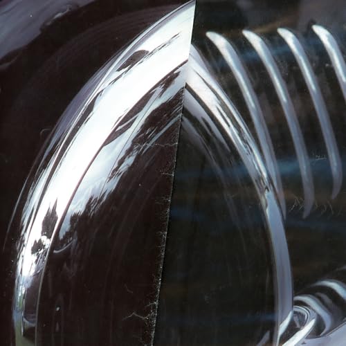 Close-up of shiny, dark vinyl record with visible grooves and reflections.