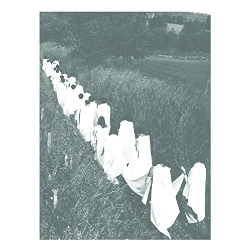 Black and white photo of figures in white robes walking in a field.