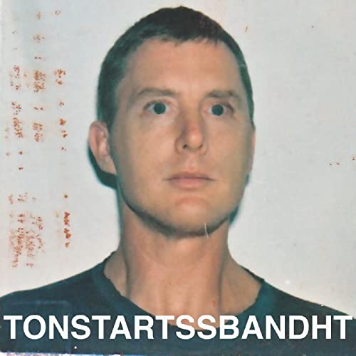 Close-up portrait of a man with the text "TONSTARTSSBANDHT" below.