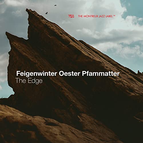 CD cover with a large rock formation against a cloudy sky.