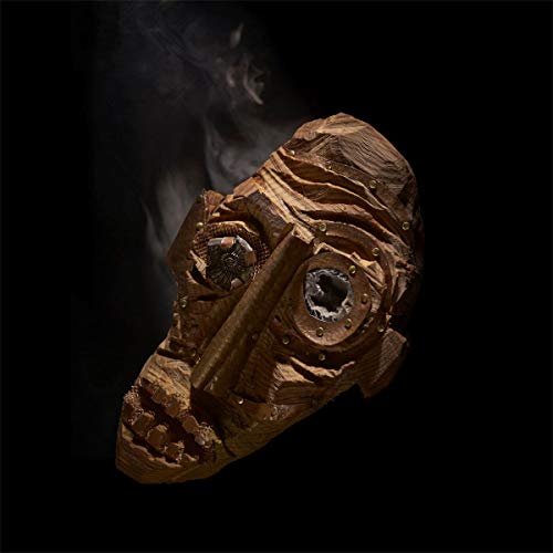 Wooden mask with carved features and metal accents against a dark background.