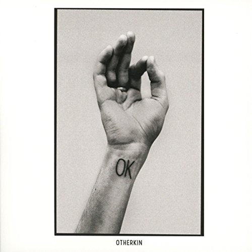 Black and white CD cover with a hand displaying the "OK" sign.