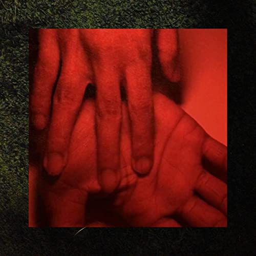 Close-up of hands in shades of red against a dark background.
