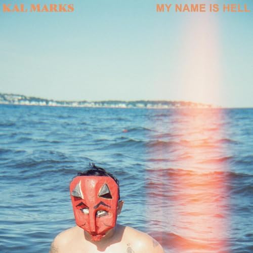 Person with a red devil mask emerging from blue ocean water.