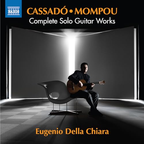 Guitarist Eugenio Della Chiara sits playing in a modern, minimalist room.