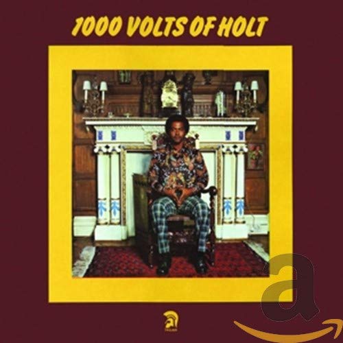 Album cover: man seated before a fireplace in a patterned shirt.