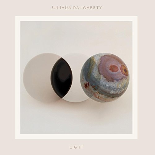 Album cover showing a patterned stone sphere overlapping a black circle on beige background.