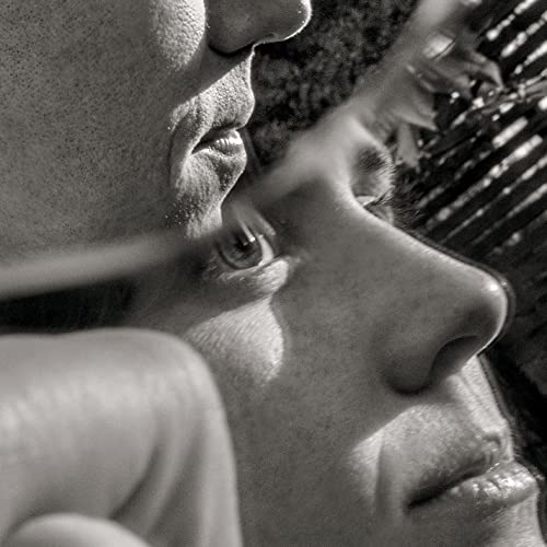 Black and white close-up of two faces, eyes looking towards each other.