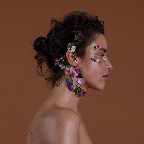 Profile of a woman with flowers adorning her hair and face.