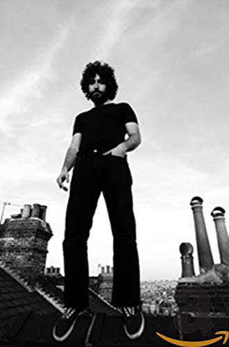 Black and white photo of a man standing on a rooftop.