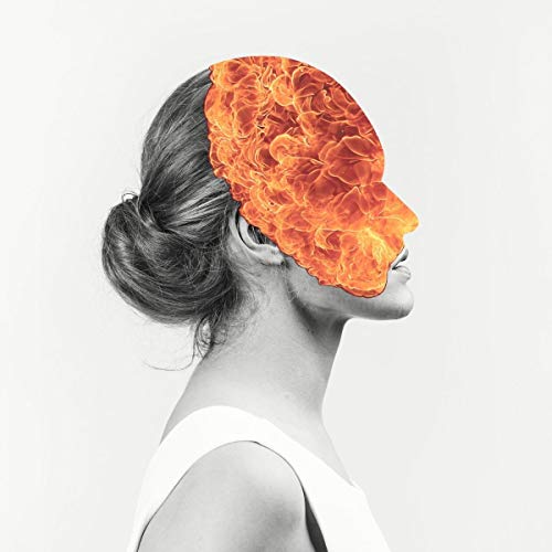Woman in profile with a fiery orange mask covering her face.