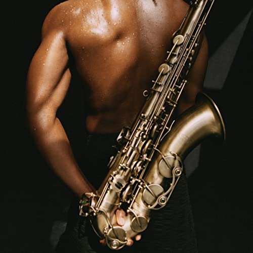 Torso of a person holding a golden saxophone against a dark background.