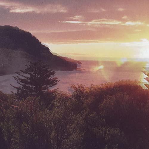 Coastal landscape with orange and pink sunset over the ocean.