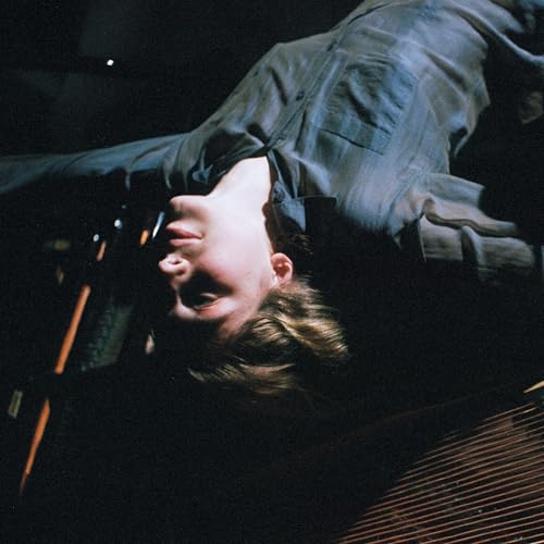Close-up of a person lying down, looking up at a harp.