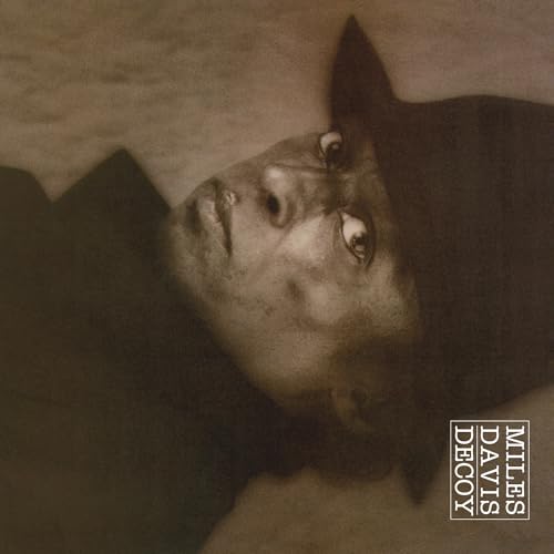 Close-up of Miles Davis’s face in shadow, album cover “Decoy”.