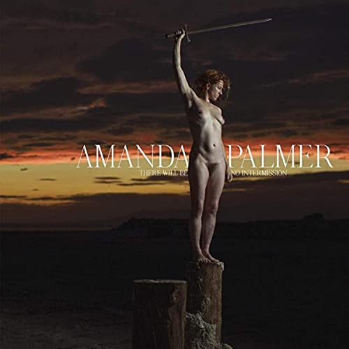 Nude woman with raised sword stands on a tree stump at sunset.