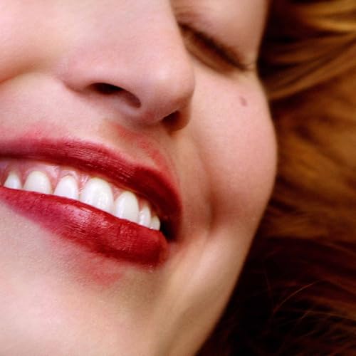 Close-up of a person smiling with red lipstick and white teeth.