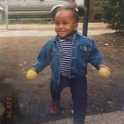 Young child in denim jacket holding lemons, outdoor setting.