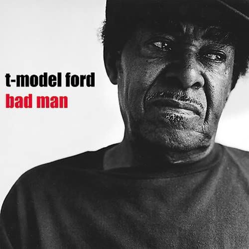 Black and white portrait of a man with a stern expression, album cover.