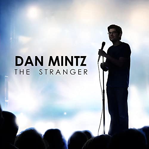Dan Mintz on stage with a microphone, album cover for "The Stranger.