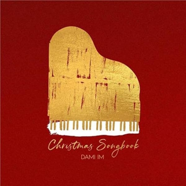 Red background with a gold piano and text “Christmas Songbook” by Dami Im.