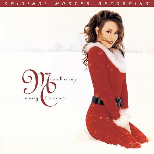 Mariah Carey in red suit on snowy “Merry Christmas” album cover.