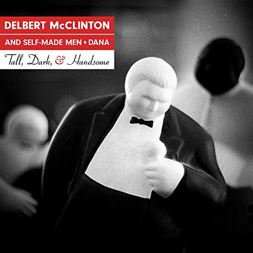 Black and white album cover featuring a plastic toy man in a tuxedo.