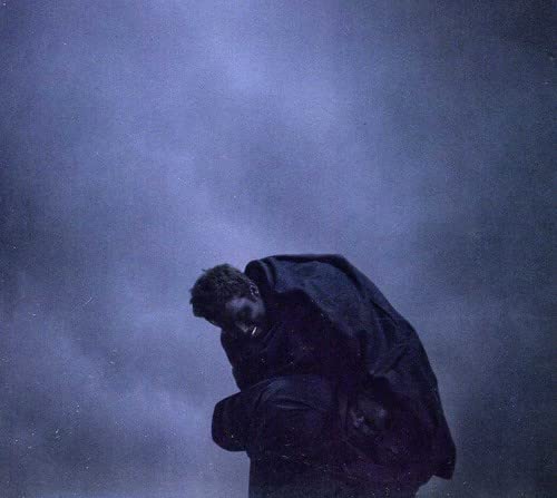 Dark album cover featuring a person with their head bowed in shadow.