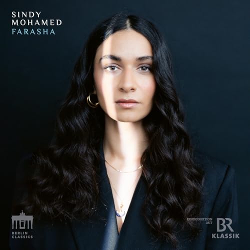 Close-up portrait of Sindy Mohamed with long, dark curly hair.