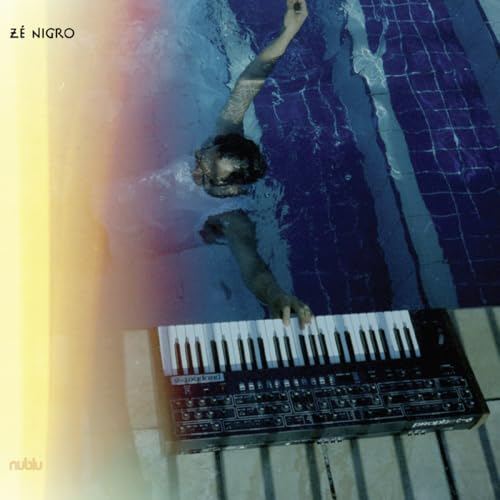 Person submerged in blue water with a piano and synthesizer.