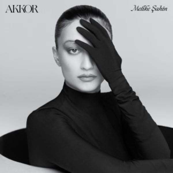 Black and white portrait of Melike Şahin with hand covering eye.