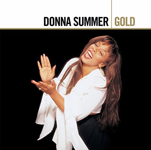 Donna Summer smiling and clapping, wearing a white top against a black background.