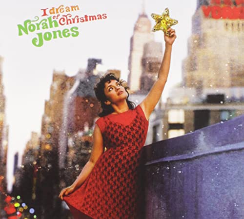 Norah Jones on album cover, holding a gold star, city background.