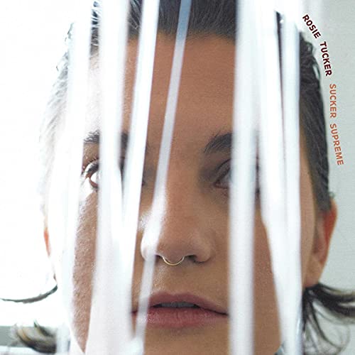 Close-up of Rosie Tucker with white ribbons partially obscuring her face.