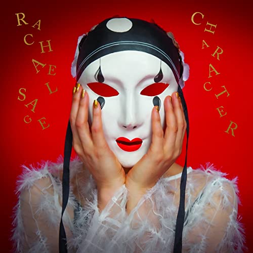 Person wearing a white pierrot mask with red details, gold lettering.