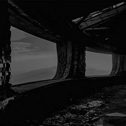 Dark, grainy image of a concrete underpass with a cloudy sky.