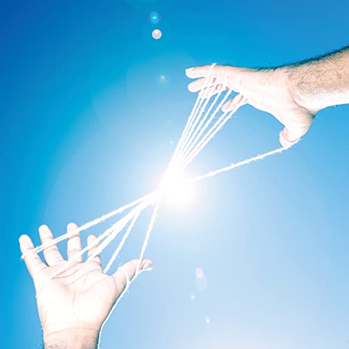 Two hands stretch white strings against a bright blue sky with lens flare.