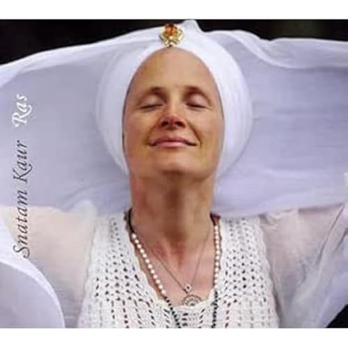 Woman with white turban and necklace, eyes closed in peaceful expression.