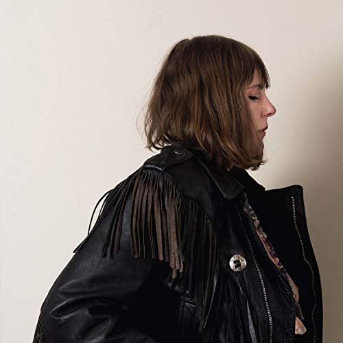 Woman with brown hair wearing a black leather jacket with fringe.