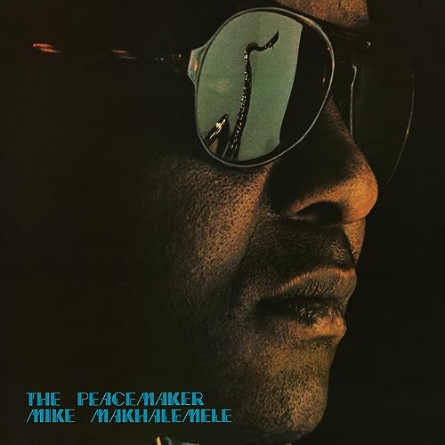 Close-up of a man wearing sunglasses reflecting a giraffe silhouette.
